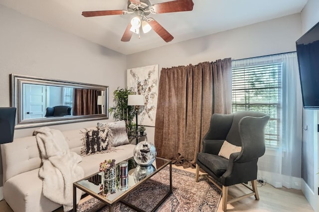 living area featuring a ceiling fan and wood finished floors