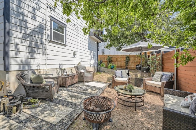 view of patio / terrace featuring an outdoor living space with a fire pit and a fenced backyard