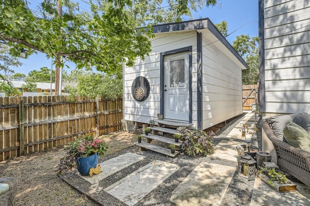 view of outbuilding with an outbuilding, fence, and entry steps