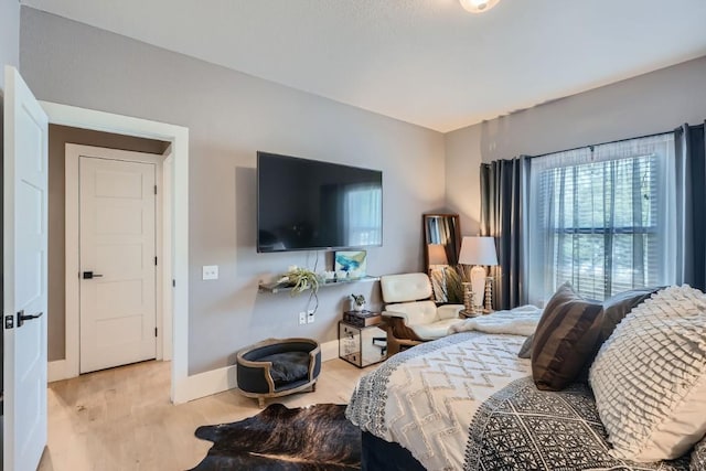 bedroom with wood finished floors and baseboards