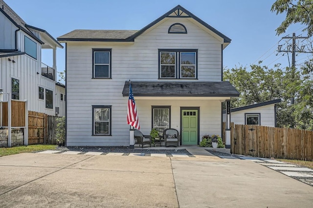 view of front facade featuring a porch and fence