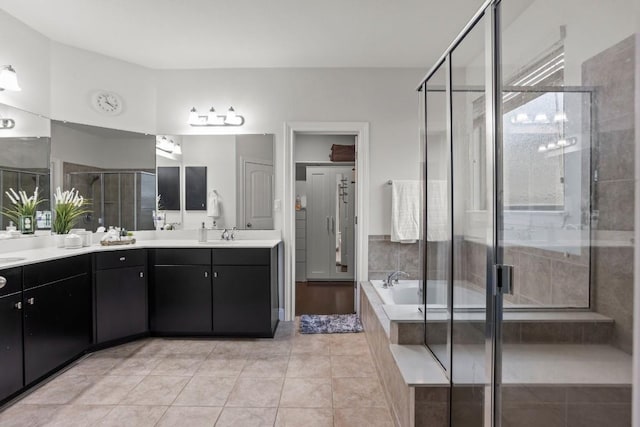 full bath featuring double vanity, a garden tub, a shower stall, and tile patterned floors