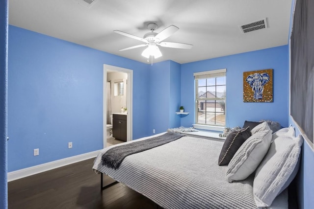 bedroom featuring wood finished floors, visible vents, baseboards, ceiling fan, and ensuite bathroom