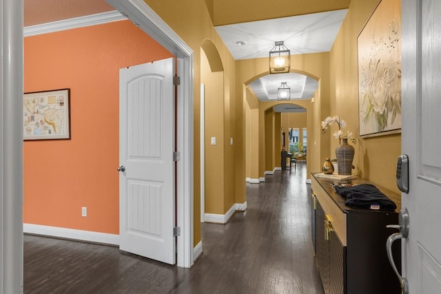 entryway featuring dark wood-style floors, arched walkways, and baseboards