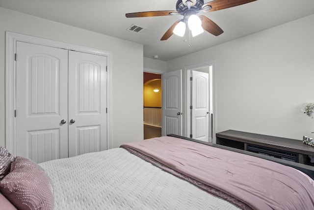 bedroom featuring a ceiling fan, arched walkways, visible vents, and a closet