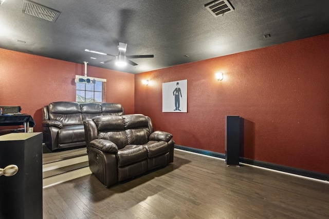 cinema room with visible vents, a textured ceiling, a textured wall, and wood-type flooring