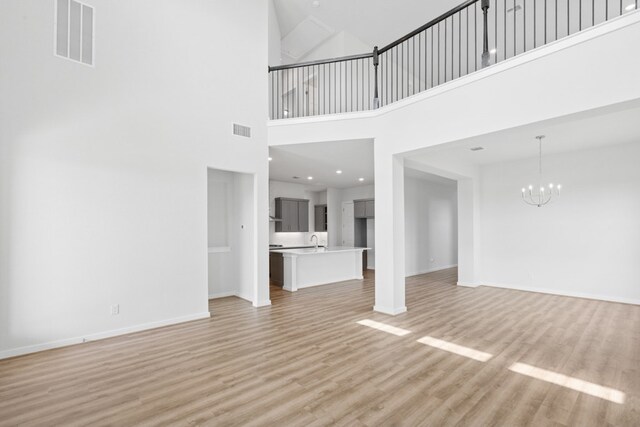 4419 College Square Dr, Round Rock, TX 78665 - unfurnished living room featuring a chandelier, visible vents, and light wood-style flooring