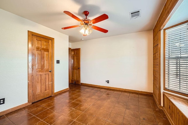 unfurnished room featuring a ceiling fan, baseboards, and visible vents