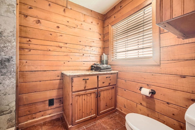 bathroom featuring wooden walls and toilet