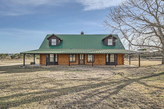 view of front of home with covered porch, log exterior, and metal roof