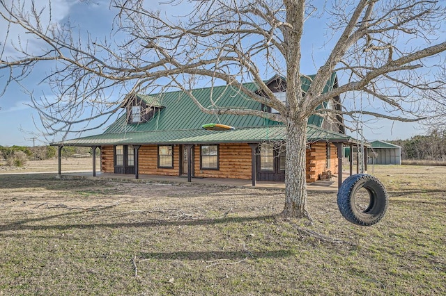 log-style house with a porch, log siding, and metal roof