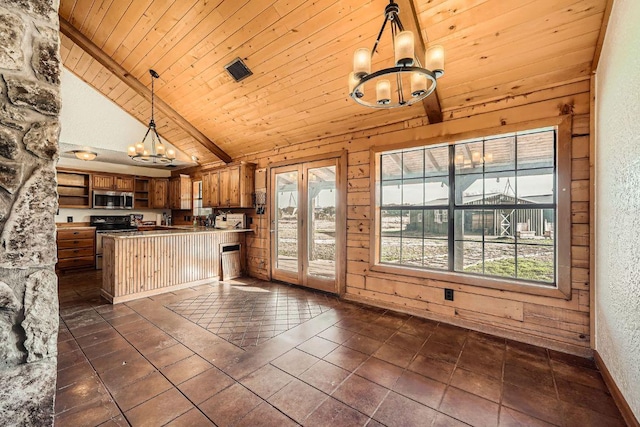 kitchen with brown cabinets, a notable chandelier, appliances with stainless steel finishes, and plenty of natural light