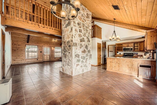 kitchen featuring dark tile patterned floors, open floor plan, stainless steel appliances, an inviting chandelier, and wood ceiling