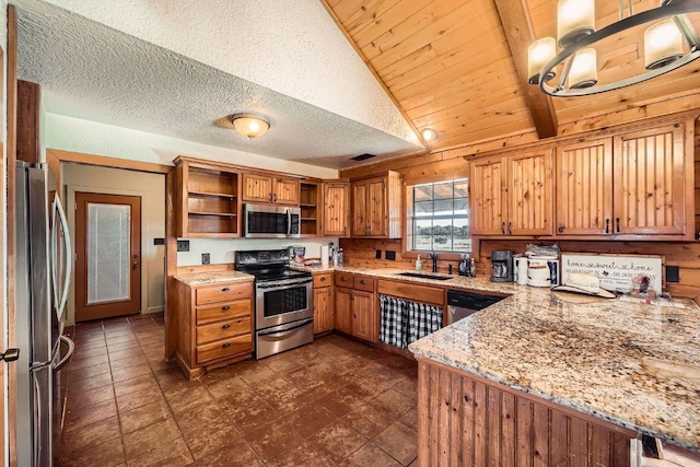 kitchen with light stone countertops, open shelves, a sink, stainless steel appliances, and a textured ceiling