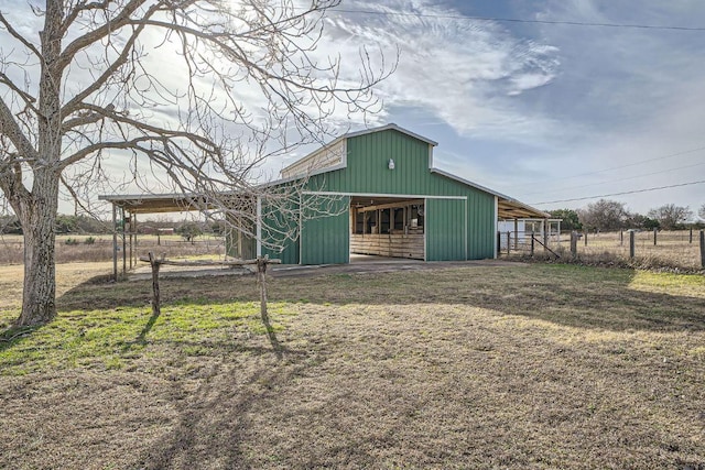 view of outbuilding with an outdoor structure, fence, driveway, and an exterior structure