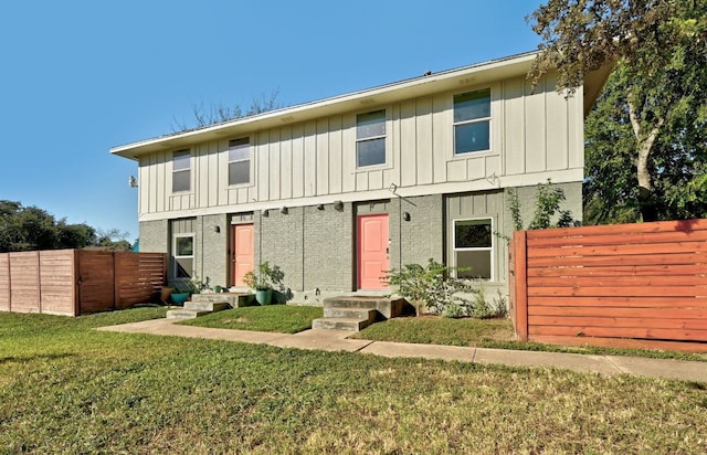 view of property featuring a front yard, fence, and board and batten siding