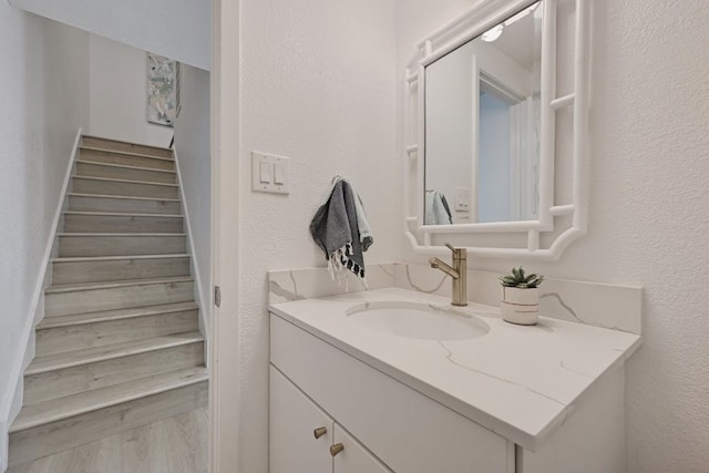 bathroom with vanity and a textured wall