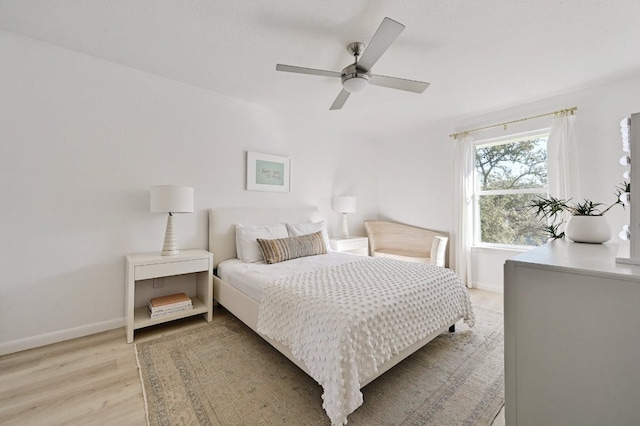 bedroom featuring ceiling fan, baseboards, and light wood-style floors