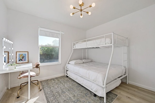 bedroom with an inviting chandelier, wood finished floors, and baseboards