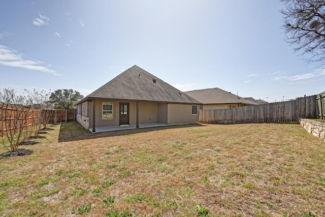 back of property featuring a patio area, a lawn, and a fenced backyard