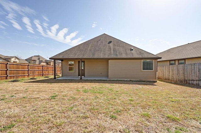 back of property featuring a patio area, a lawn, and a fenced backyard