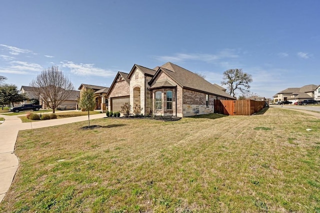 view of home's exterior with driveway, fence, a yard, an attached garage, and brick siding