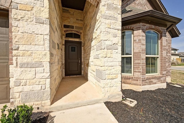 entrance to property with brick siding and stone siding