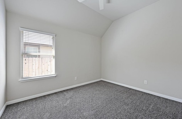 empty room with vaulted ceiling, a ceiling fan, baseboards, and carpet floors