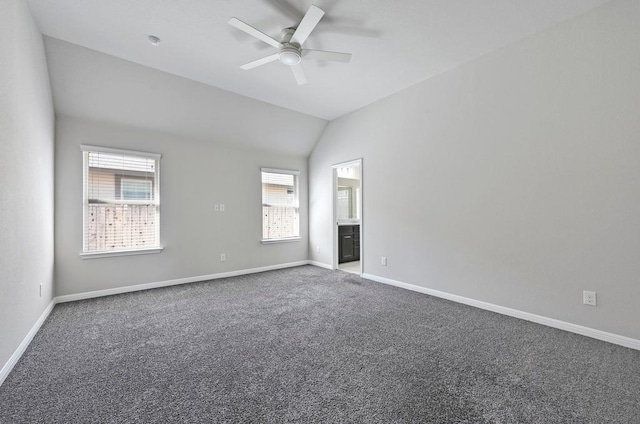 carpeted empty room with baseboards, lofted ceiling, and a ceiling fan