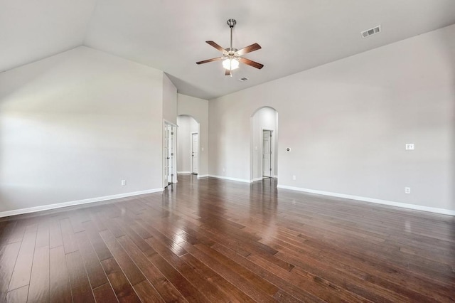 unfurnished living room with baseboards, dark wood finished floors, arched walkways, ceiling fan, and vaulted ceiling