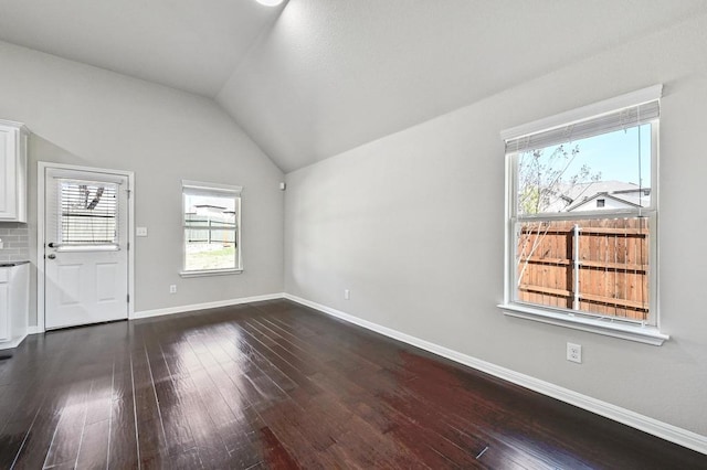 interior space with baseboards, dark wood-type flooring, and lofted ceiling