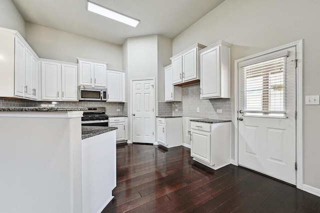 kitchen featuring decorative backsplash, appliances with stainless steel finishes, and dark wood finished floors