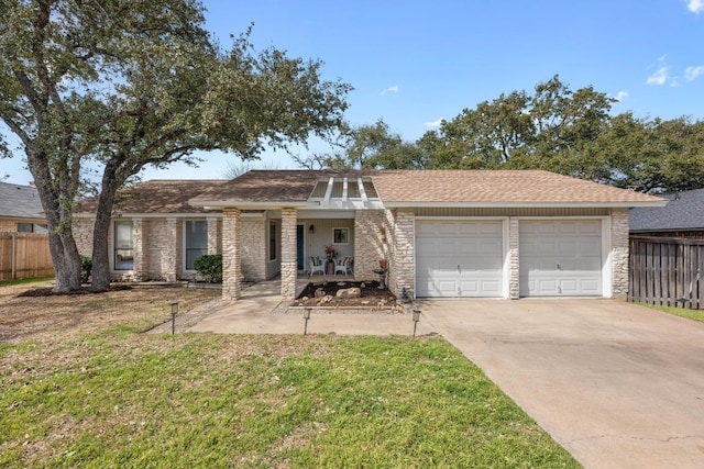 view of front of house with a front yard, an attached garage, fence, and driveway