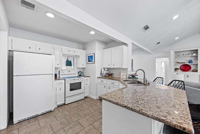 kitchen featuring visible vents, a sink, white appliances, a peninsula, and light stone countertops