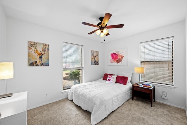 carpeted bedroom with a ceiling fan and baseboards