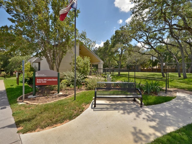 view of community featuring a lawn and fence