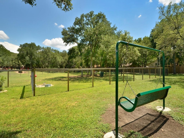 view of property's community with a lawn and fence