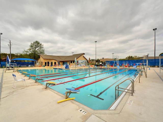 community pool featuring fence and a patio area