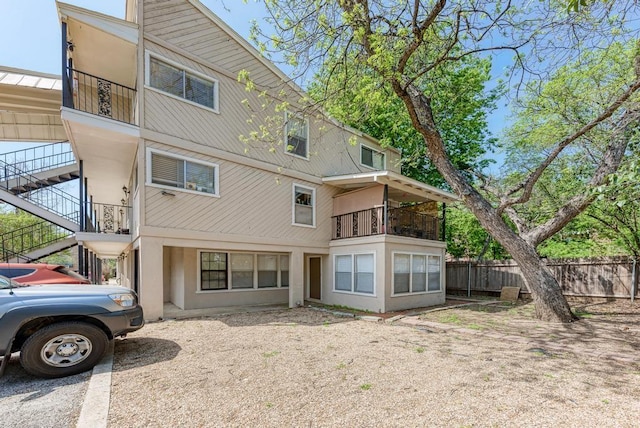 back of property featuring stairs and fence