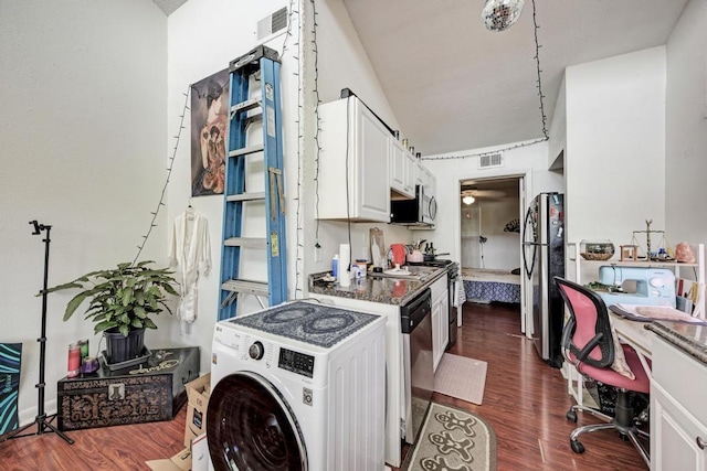 kitchen featuring visible vents, dark wood finished floors, washer / dryer, stainless steel appliances, and white cabinets