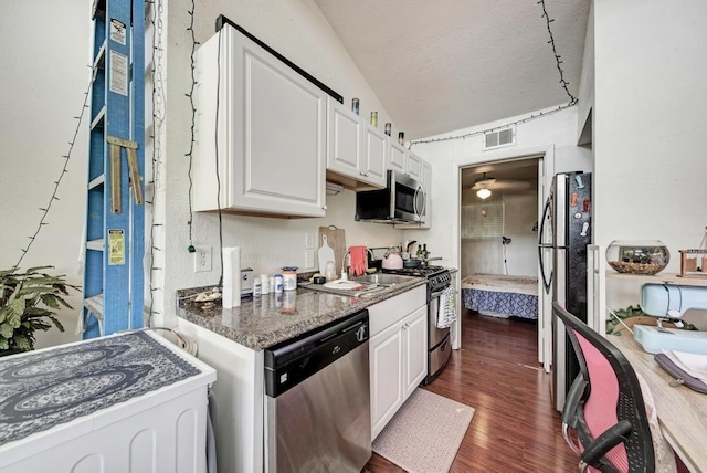 kitchen with visible vents, dark wood-type flooring, a sink, stainless steel appliances, and white cabinets