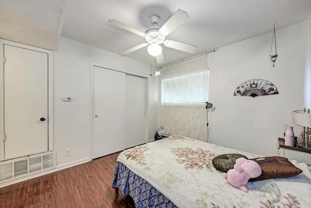 bedroom featuring visible vents, a ceiling fan, a textured ceiling, wood finished floors, and a closet