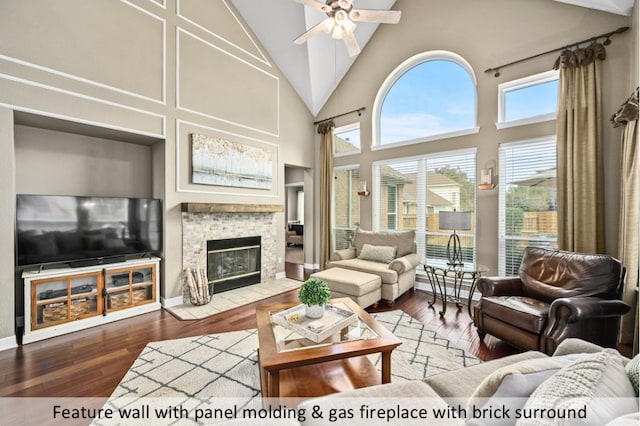 sunroom with vaulted ceiling, a fireplace with flush hearth, and ceiling fan