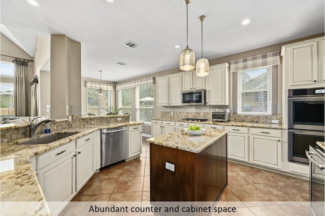 kitchen featuring visible vents, stainless steel appliances, decorative backsplash, and a sink