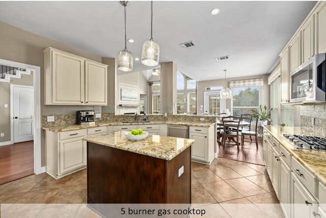 kitchen with visible vents, backsplash, light tile patterned floors, appliances with stainless steel finishes, and a peninsula