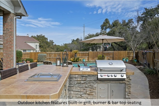 view of patio / terrace featuring outdoor dining space, area for grilling, a fenced backyard, and a grill