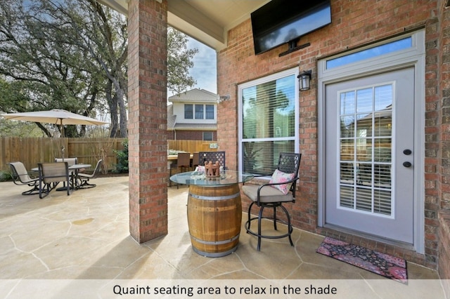 view of patio with outdoor dining space and fence