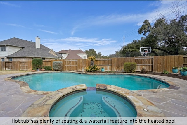 view of pool featuring a pool with connected hot tub and a fenced backyard