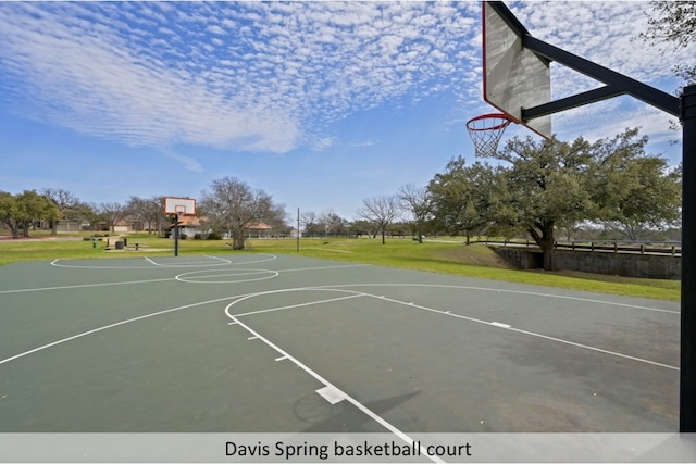 view of basketball court with community basketball court and a lawn