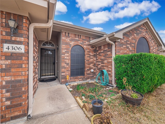 view of exterior entry with brick siding